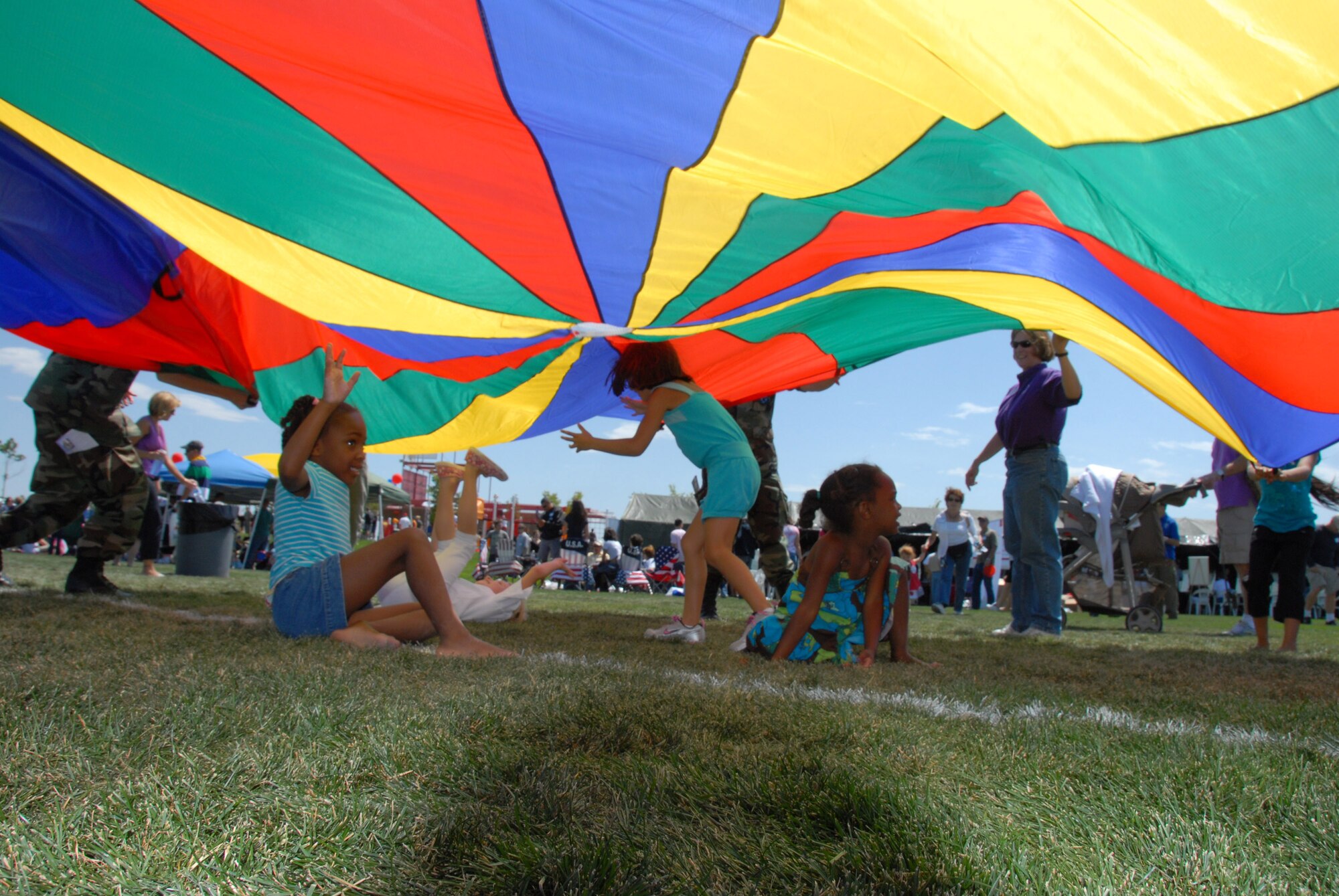 Children play under a bright parachute at the Aurora Sports Complex on August 16, 2009.  The Welcome Home Picnic celebrated the return of more then 250 Airmen from Iraq.
