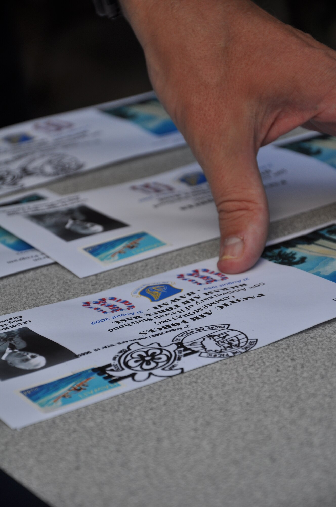 HICKAM AIR FORCE BASE, Hawaii – Master Sgt. James Register, Pacific Air Forces Air Postal Squadron, stamps the very first postmark cancellation for collectors Aug. 21 at the Courtyard of Heroes. In honor of Hawaii's 50th anniversary of statehood, the PACAF Air Postal Squadron issued this pictorial commemoration to honor the relationship between the U.S. Armed Forces and their host state. (U.S. Air Force photo/Staff Sgt. Carolyn Viss)
