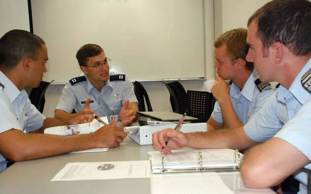 Capt. Luke Sauter reviews ins and outs of rocketry to Cadets 1st Class Aaron Price, Wayne Black and Nolan Brock. Captain Sauter was recently selected as the Air Force nominee for the 60th-annual Arhut S. Flemming Award for Applied Science, Engineering and Mathematics. He is an astronautics course instructor with the U.S. Air Force Academy's Department of Astronautics. (U.S. Air Force photo/Ann Patton)