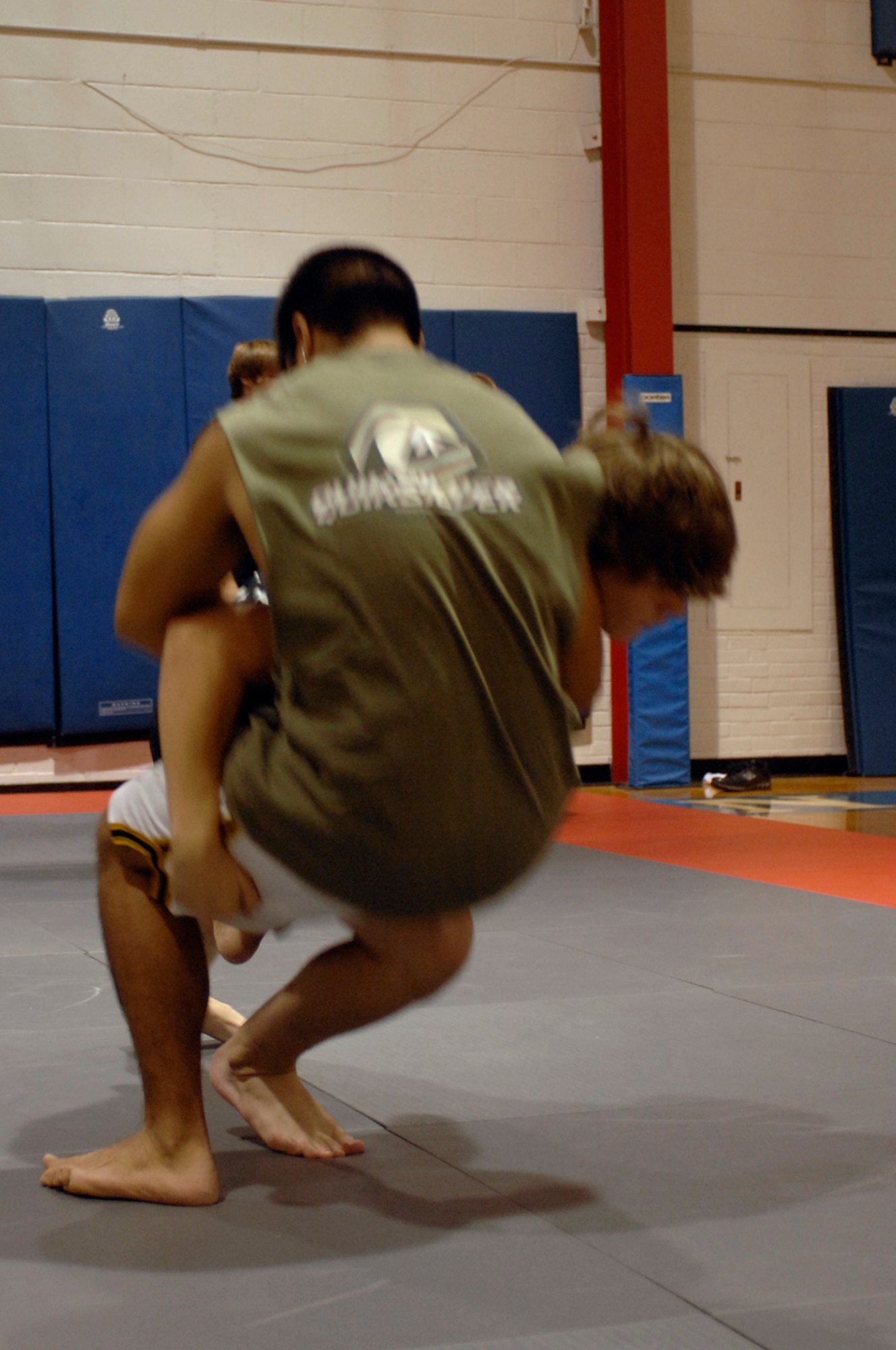 WHITEMAN AIR FORCE BASE, Mo. - Members of Team Whiteman practice a double-leg takedown Aug. 20 as taught by Dan Severn, American mixed martial artist and professional wrestler. A former UFC fighter and Pro-wrestler, Mr. Severn performed three different training sessions for Airmen and their families stationed at Whiteman. (U.S. Air Force photo/Staff Sgt. Jason Barebo)