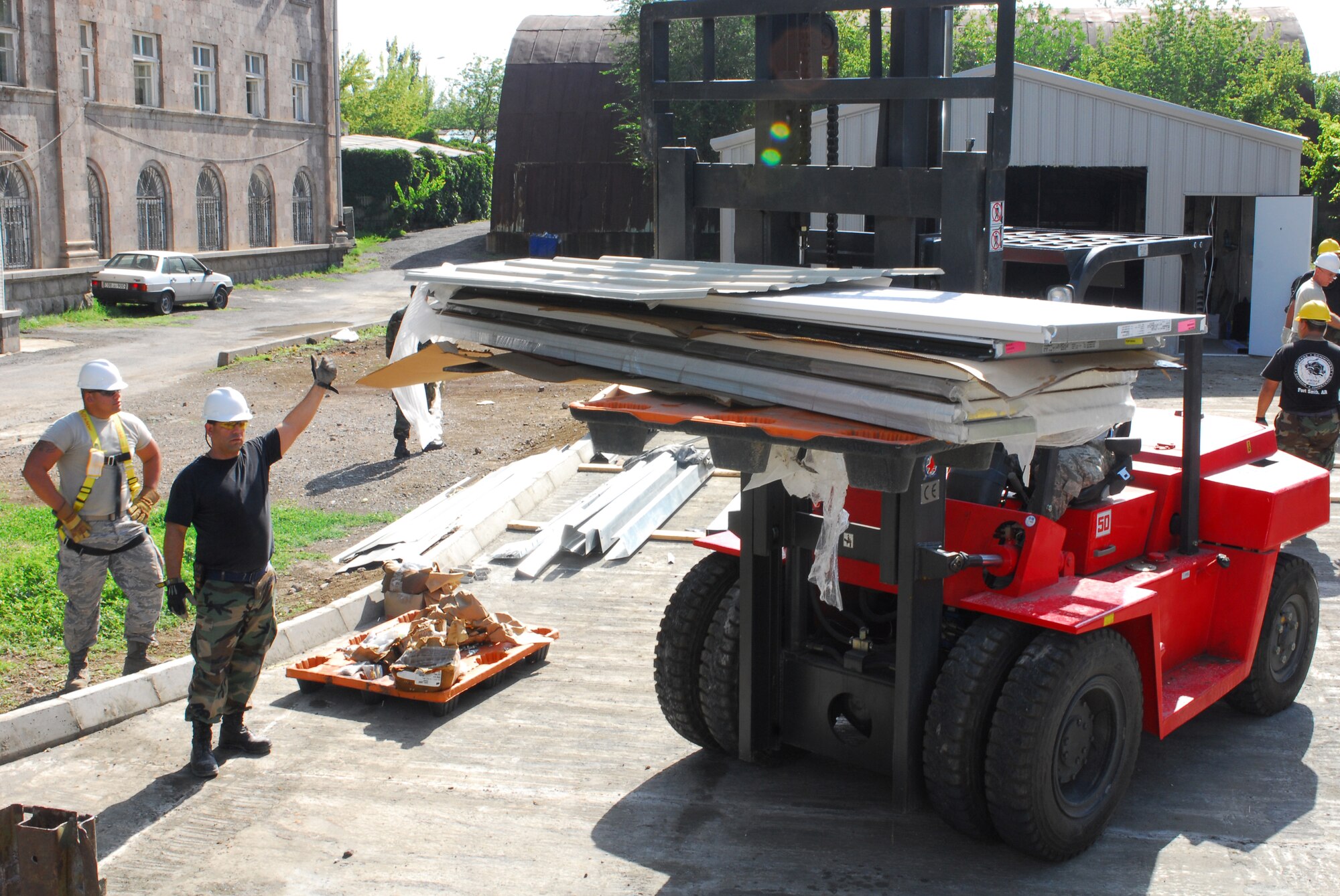 Members of the 149th Civil Engineer Squadron use a front-end loader to move construction supplies at the site of the Expeditionary Medical Support  (EMEDS) building during their deployment to Yerevan, Armenia, in the first two weeks of August 2009. Forty-eight Texas National Guard Airmen deployed from San Antonio, Texas, to support security cooperation initiatives and humanitarian assistance projects. The EMEDS building will accommodate medical equipment, supplies, tents and personnel to provide modular, rapid response for humanitarian relief and wartime contingencies.(Texas Military Forces photo by Tech. Sgt. Rene Castillo) 