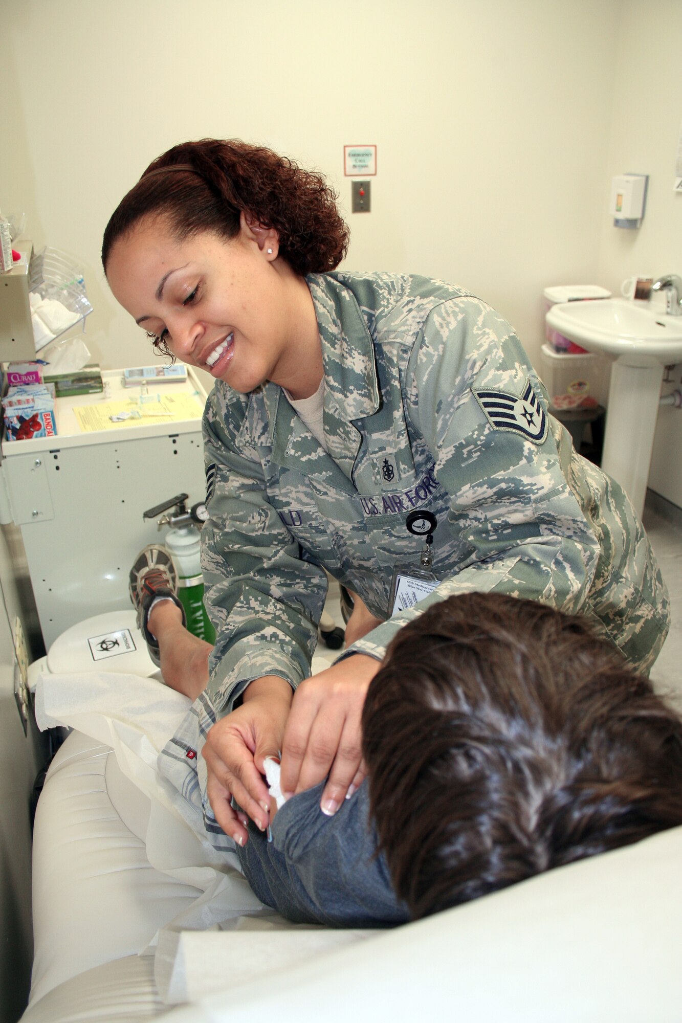 Staff Sgt. Dorothy Arnold places a band-aid on the arm Troy Ringlein after she administered a shot as part of his immunizations during the school and sports physical day held Aug. 20 at the Lajes Field, the Azores. Sergeant Arnold is assigned to the 65th Medical Operation Support Squadron, and Troy is the son of Maj. Thomas Ringlein, 65th Logistics Readiness Squadron director of operations. (U.S. Air Force photo/Capt. George Tobias) 