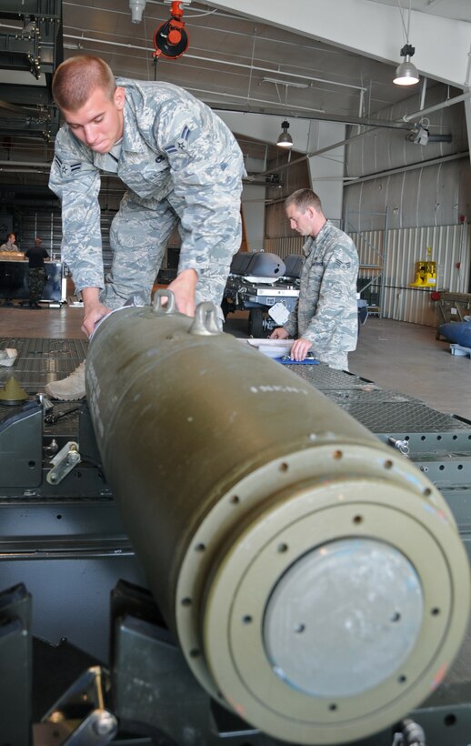 Airman 1st Class Derrick Scott, 28th Munitions Squadron conventional maintenance crew member, pieces together a Guided Bomb Unit-38 while Senior Airman Shawn Monteer, 28 MUNS conventional maintenance crew member, checks over a Technical Order manual here, August 20.  The GBU-38 is a 500-pound bomb which is commonly used in the B-1B Lancer's arsenal. (U.S Air Force photo/Airman 1st Class Anthony Sanchelli)