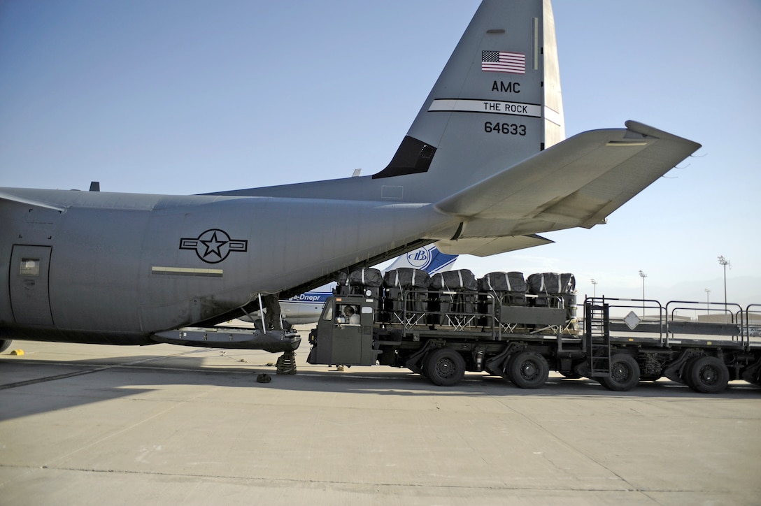 Pallets of JP-8 fuel rigged for an airdrop are loaded into the cargo ...