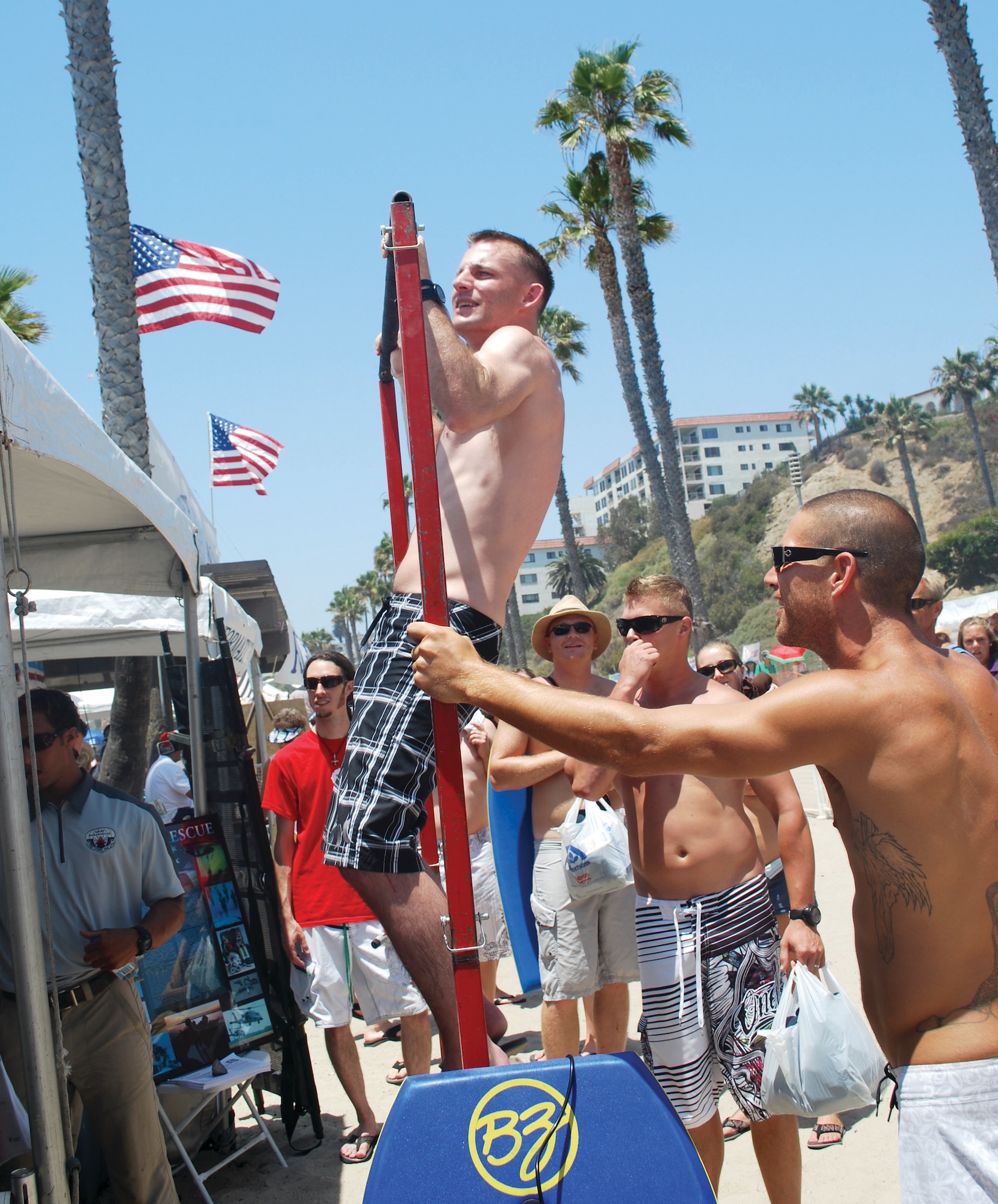 Beach-goers pause to do pull-ups at the pararescue recruiting booth at the San Clemente Ocean Festival, Aug. 18. Recruiters from March ARB teamed up with Tuscon, Ariz. recruiters for the event. (U.S. Air Force courtesy photo)