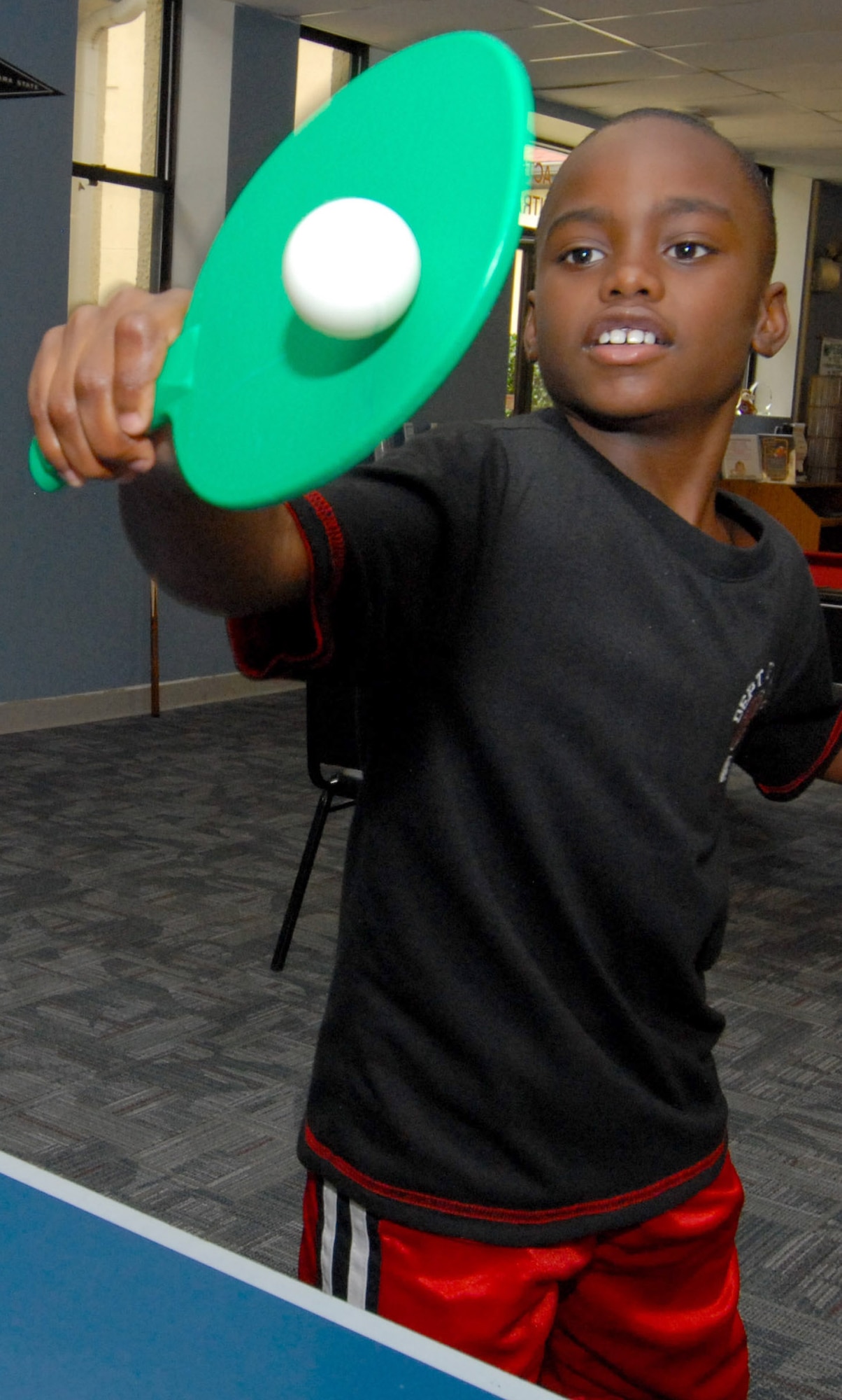 Cameron McClendon, 9, enjoys a game of Ping Pong at the Maxwell Youth Center. Youth ages 9 to 12 can use the open recreation area of the center during Pre-teen hours. (U.S. Air Force photo/Jamie Pitcher)