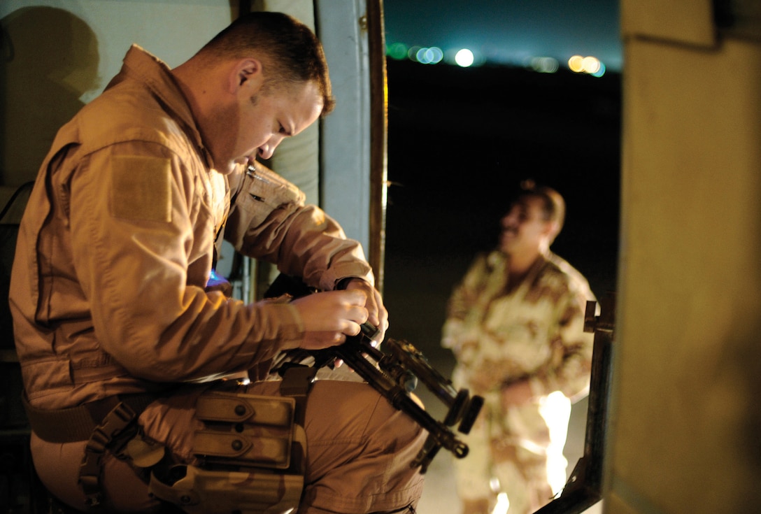 Technical Sgt. Onnez Rodriquez-Massas, 1st Helicopter Squadron special missions flight engineer, inspects a PKM machine gun on an Iraqi Mi-17 helicopter prior to a night mission July 12 at Camp Taji, Iraq. The 721st AEAS trains the Iraqi air force in many functions, including helicopter pilot and aerial gunner training. Sergeant Rodriguez-Massas is an aerial gunner and Team Andrews member assigned to the 721st Air Expeditionary Advisor Squadron. (U.S. Air Force photo/ Staff Sgt. Michael B. Keller)