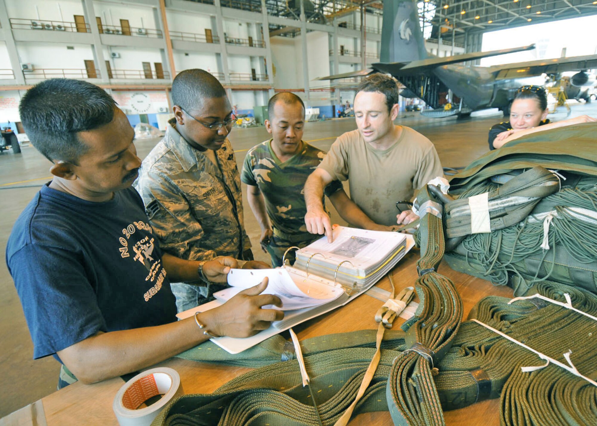 Senior Airman Warren Smith (second from left) views technical orders with personnel from the Malaysian, Australian and New Zealand air forces Aug. 19 at Subang Royal Mayaysian Air Force Base, Malaysia. The airmen are participating in Pacific Airlift Rally 2009. Sergeant Smith is a 374th Logistics Readiness Squadron combat mobility flight technician from Yokota Air Base, Japan. (U.S. Air Force photo/Staff Sgt. Veronica Pierce) 
