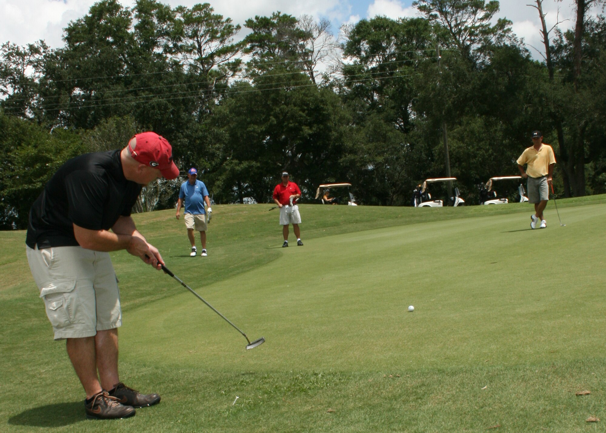 Chris James, member of the Air Force Research Laboratory intramural golf team, completes an 8-foot birdie putt clinching the win for the AFRL team during the 2009 Eglin Intramural Golf tournament. (Photo/2nd Lt. Andrew Caulk)