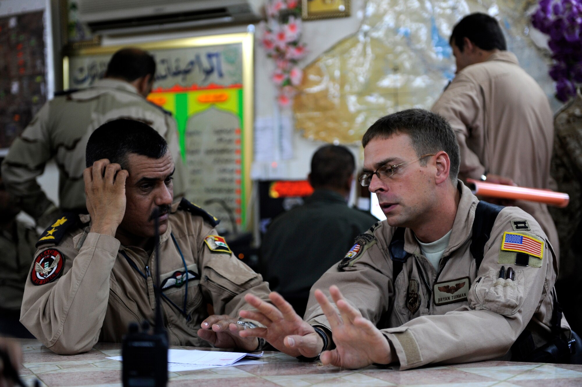 U.S. Air Force Capt. Bryan Tuinman an Mi-171 pilot with the 721st Air Expeditionary Advisor Squadron, discusses an upcoming mission with an Iraqi Air Force Airmen at Taji Air Base, Iraq, July 13, 2009.  Airmen from the 721st help train and advise Iraqi Airmen in many aspects of helicopter pilot, aerial gunner, and maintenance training.  (U.S. Air Force photo by Staff Sgt. Michael B. Keller) (Released) 
