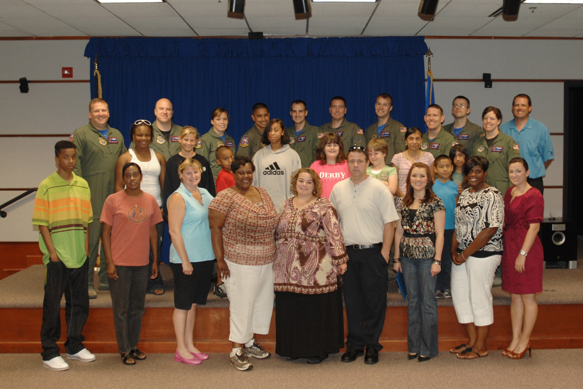 Members of the 349th Air Refueling Squadron and Kansas Big Brothers Big Sisters staff members before a tour of a  KC-135 Stratotanker at McConnell Air Force Base, Kan. on Aug.14. Squadron members presented KBBS youths with gift cards for school supplies and school fees.  (U.S. Air Force photo / Staff Sgt. Jamie Train) 