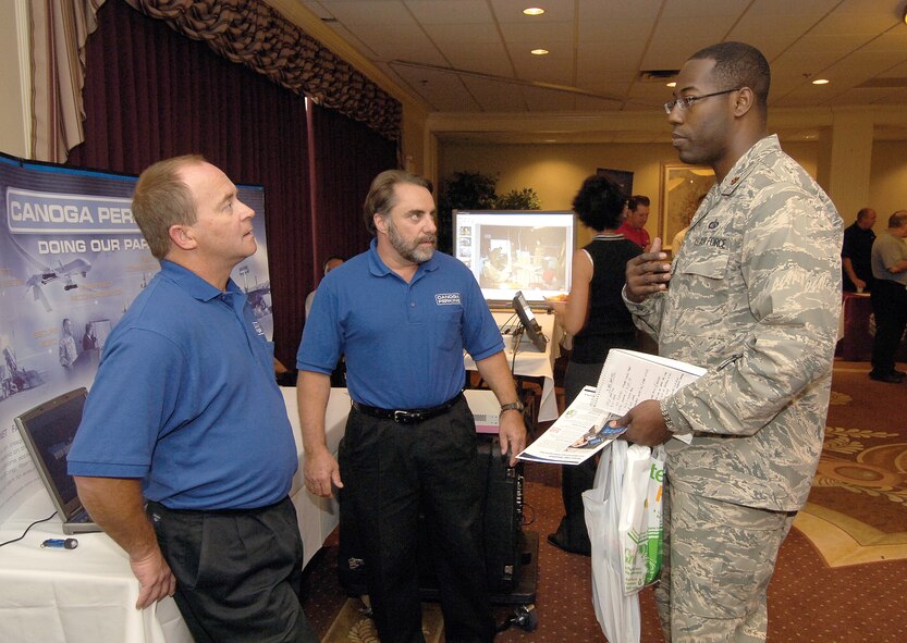 Maj. Noland Greene, commander of the 34th Combat Communications Squadron, talks with Canoga Perkins representatives Jim Maguire, left, and Keith Wynn during the AFCEA Information Technology Expo held Aug. 11 and 12 at the Tinker Club.  “I’m looking at options that will make us lighter, leaner,” said Major Greene. (Air Force photo by Margo Wright)