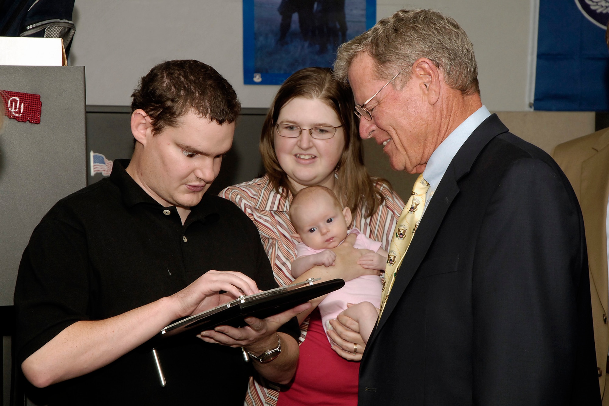 David Gwin, who works for Oklahoma League of the Blind as a switchboard operator at Tinker, received the Peter J. Salmon Award as Employee of the Year from National Industries for the Blind. During a recent visit to Tinker, Senator James Inhofe presented Mr. Gwin with a plaque while Mr. Gwin’s wife Kristel and their daughter Gabrielle look on. (Air Force photo by Kelly White)