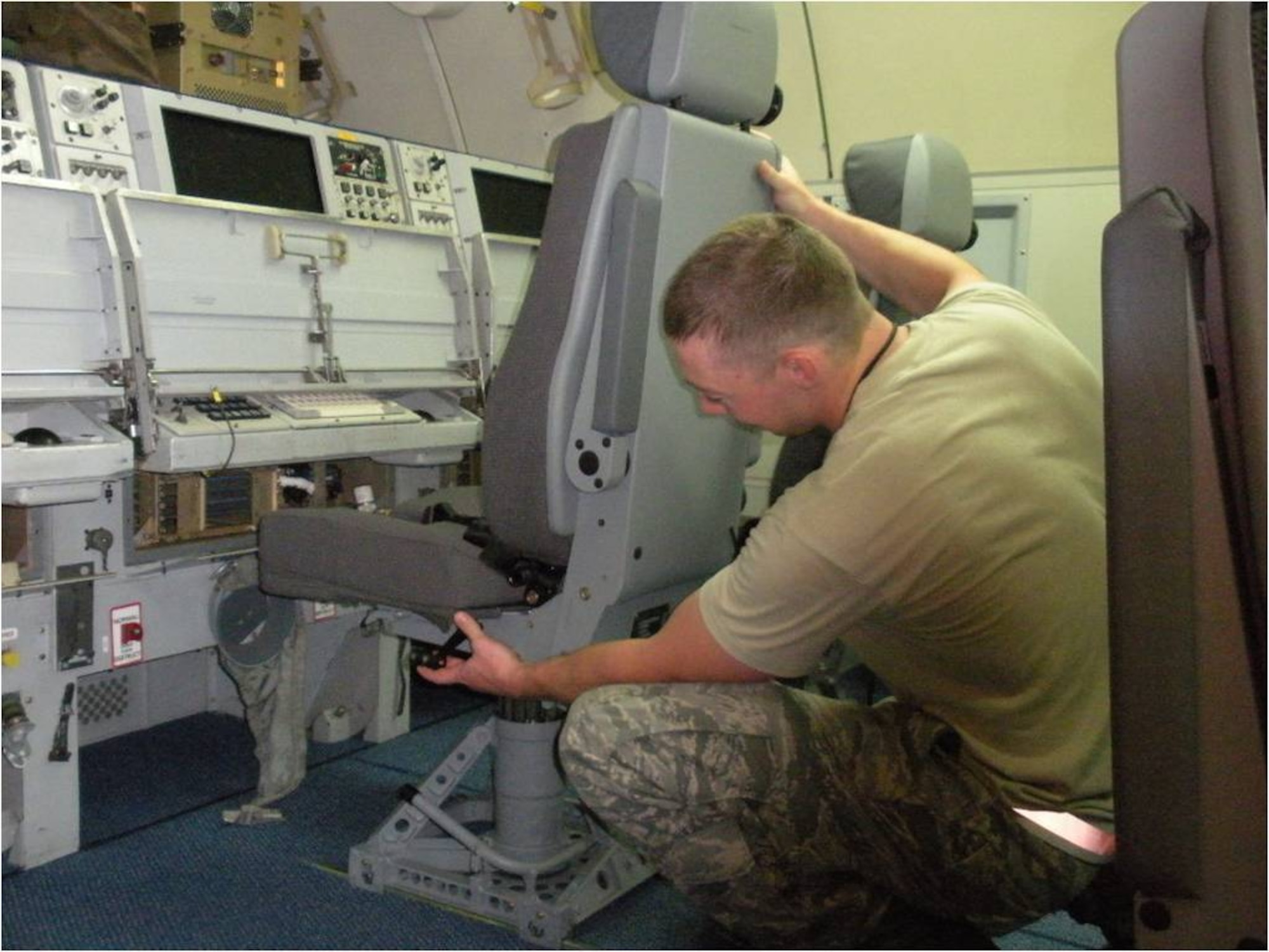 HANSCOM AIR FORCE BASE, Mass. -- A maintenance crew member at Tinker AFB, Okla., installs a new operator stations seat aboard an E-3 AWACS recently.  The new seats are expected to help alleviate back and neck stress for crews on long-duration missions.  (Courtesy Photo)
