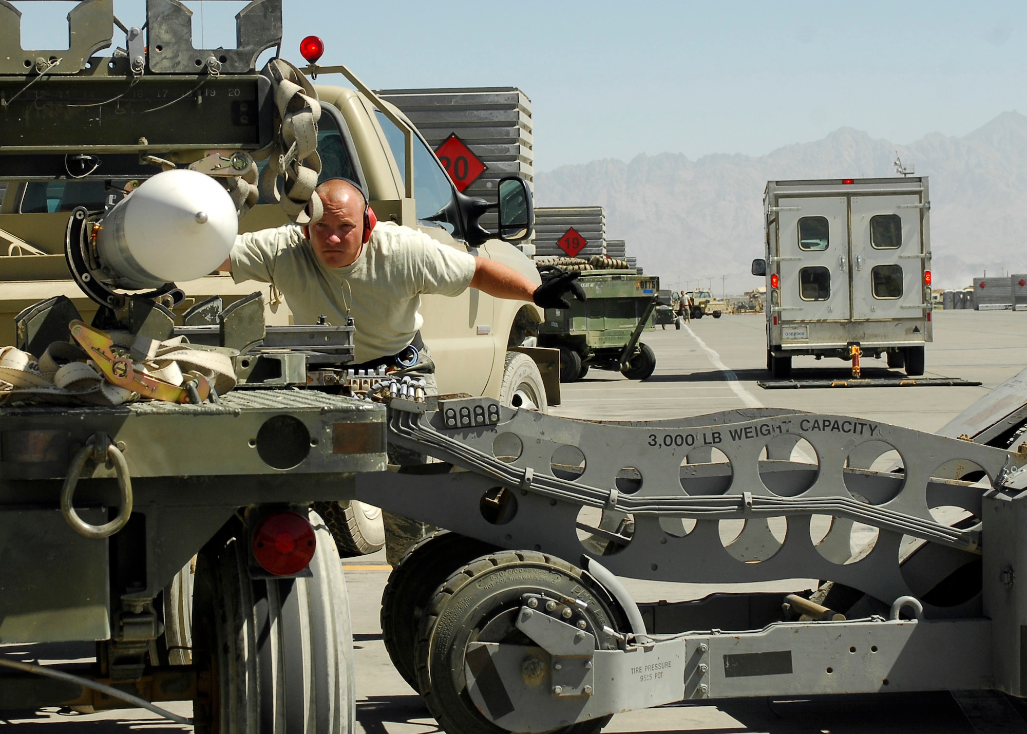 BAGRAM AIRFIELD, Afghanistan - Staff Sgt. Chad Wright, from the 421st Expeditionary Fighter Squadron, guides another airman in order to get the missile off a cart and onto an F- 16 safely, here Aug. 20. Sergeant Wright, a native of Amarillo, Texas, is deployed from the 421st Fighter Squadron at Hill Air Force Base, Utah. (U.S. Air Force photo/Senior Airman Felicia Juenke)