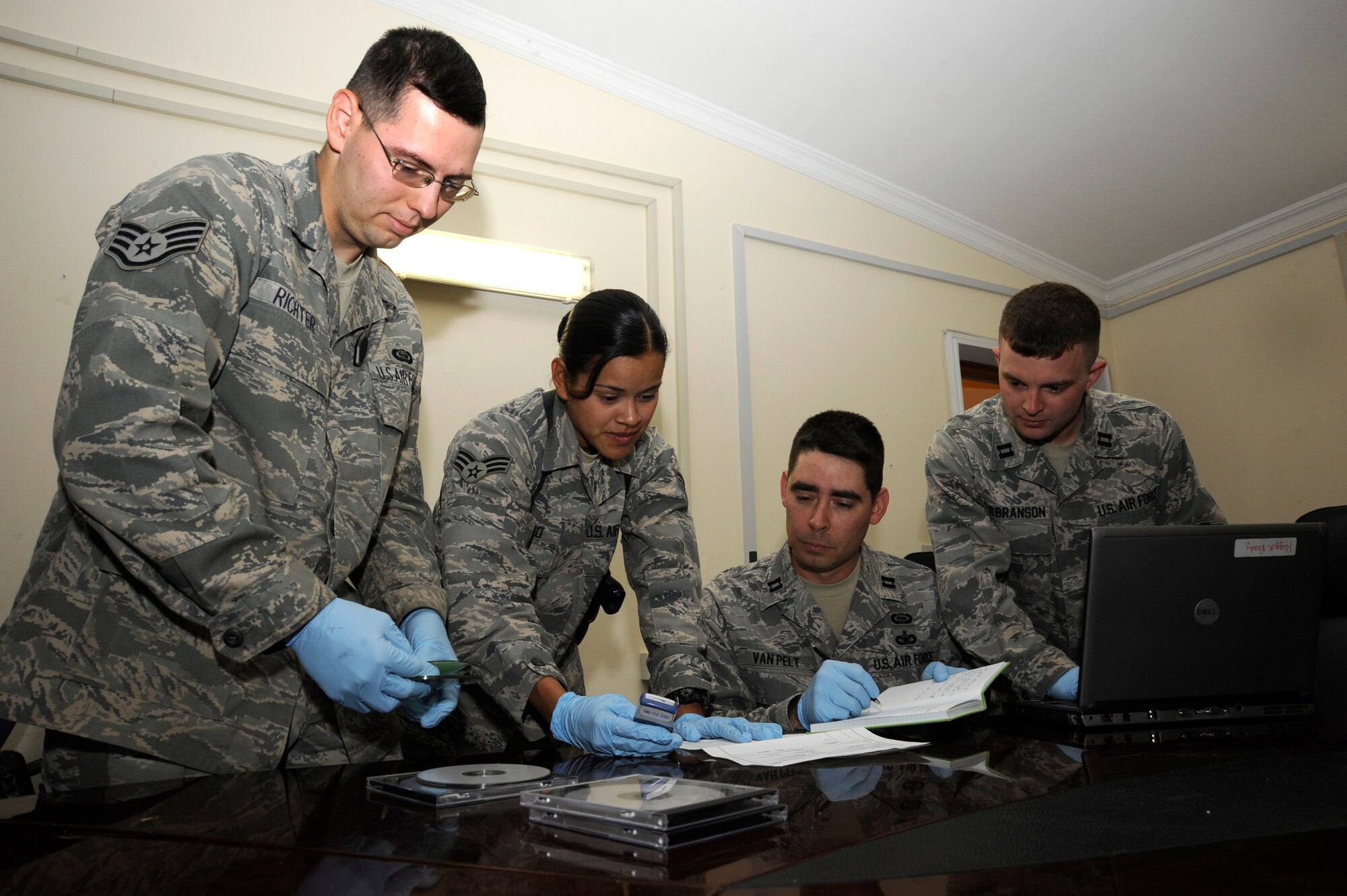 VICTORY BASE COMPLEX, Iraq -- Document Media Exploitation team members triage evidence taken from captured enemies here Aug. 21, 2009. The DOMEX mission is to exploit information from captured enemy documents, electronic media and cell phones. The team's work contributes to theater and national intelligence efforts in support of targeting and detainee operations, force protection and criminal prosecution. (U.S. Air Force photo/Tech. Sgt. Johnny L. Saldivar/Released)


