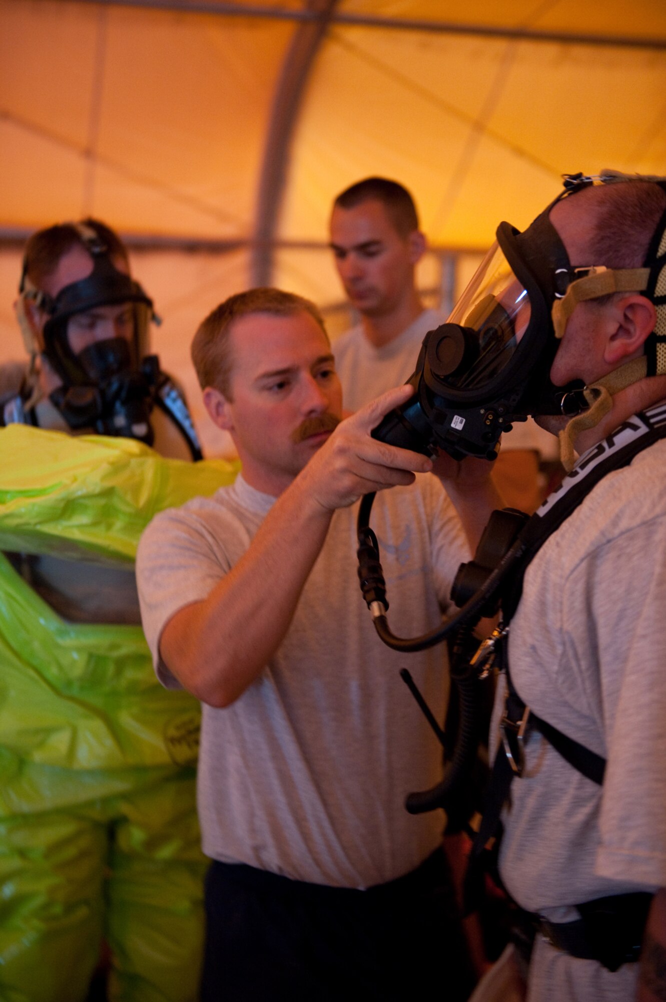Left, Staff Sgt. Aaron Burnley assists Staff Sgt. Theodore Van De Sample, both from the 379th Expeditionary Medical Group Bioenvironmental Engineering Squadron, with his Level A Self-Contained Breathing Apparatus, Aug. 13, in preparation for an exercise in Southwest Asia. Teams from the 379th Expeditionary Civil Engineer Squadron readiness and emergency management flight and 379 EMDG trained to integrate their response to a bioenvironmental hazardous situation. Both members are deployed in support of Operations Iraqi and Enduring Freedom. (U.S. Air Force Photo/ Staff Sgt. Robert Barney) 