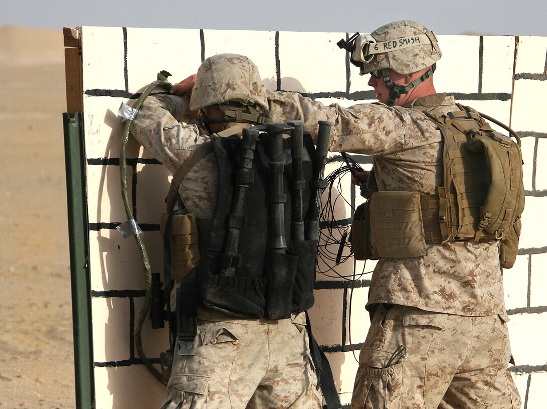 U.S. Marine combat engineers place a charge on a makeshift wall during an urban-mobility breaching course at a training area near Camp Buehring, Kuwait, Aug. 18, 2009.
