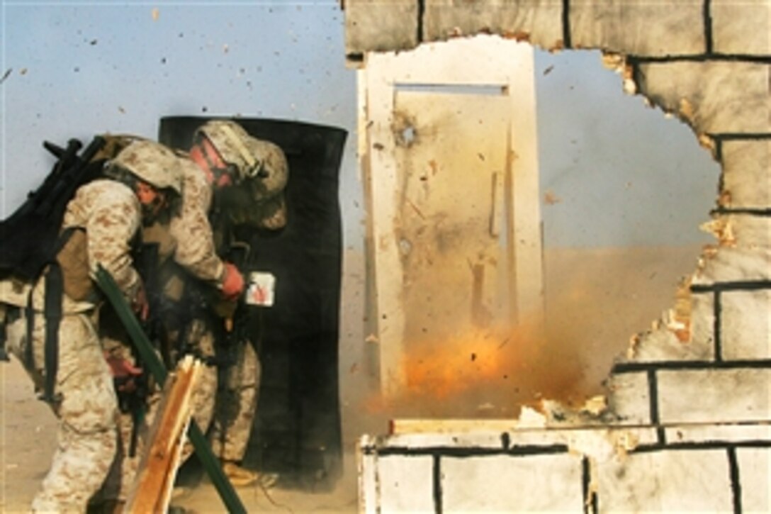 Flames, dust and debris fly from a makeshift door after U.S. Marines detonate an explosive charge during an urban-mobility breaching course at a training area near Camp Buehring, Kuwait, Aug. 18, 2009. The Marines are assigned to the Battalion Landing Team, 3rd Battalion, 2nd Marine Regiment, 22nd Marine Expeditionary Unit. The unit is ashore conducting sustainment training in Kuwait and is currently serving as the theater reserve force for U.S. Central Command.