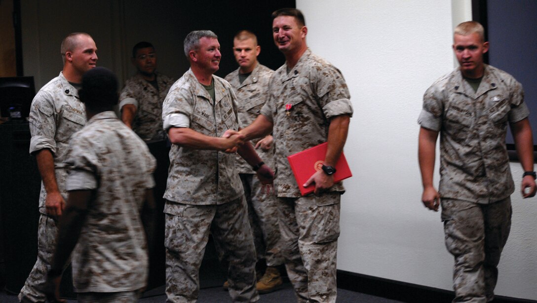 Master Gunnery Sgt. Lee Sherwood, explosive ordnance disposal staff noncommissioned officer in charge, is congratulated by Chief Warrant Officer 2 Simon Wade, Marine Wing Support Squadron 371 EOD officer in charge, after being awarded a Bronze Star Medal with Combat V during a ceremony at the Marine Corps Air Station in Yuma, Ariz., Aug. 21, 2009. Sherwood received the award for his actions under enemy fire while deployed in Afghanistan from April to September 2008.