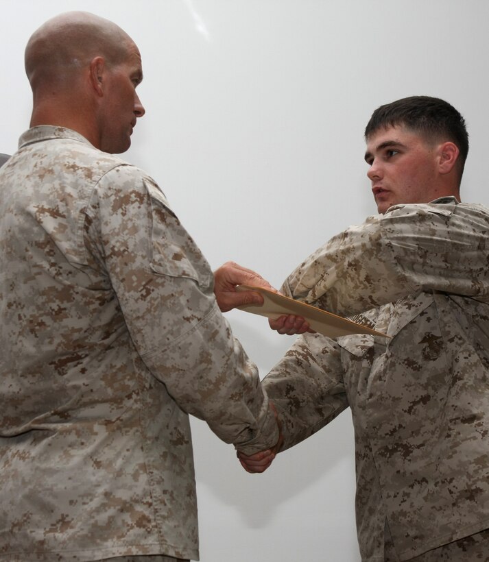 Sgt. Maj. Joseph Simpson, the sergeant major for Battalion Landing Team, 3rd Battalion, 2nd Marine Regiment, 22nd Marine Expeditionary Unit, hands out the Corporal’s Course graduation certificates at Camp Buehring, Kuwait, Aug. 21, 2009. The 22nd MEU is ashore in Kuwait to conduct sustainment training while serving as the theater reserve force for U.S. Central Command.