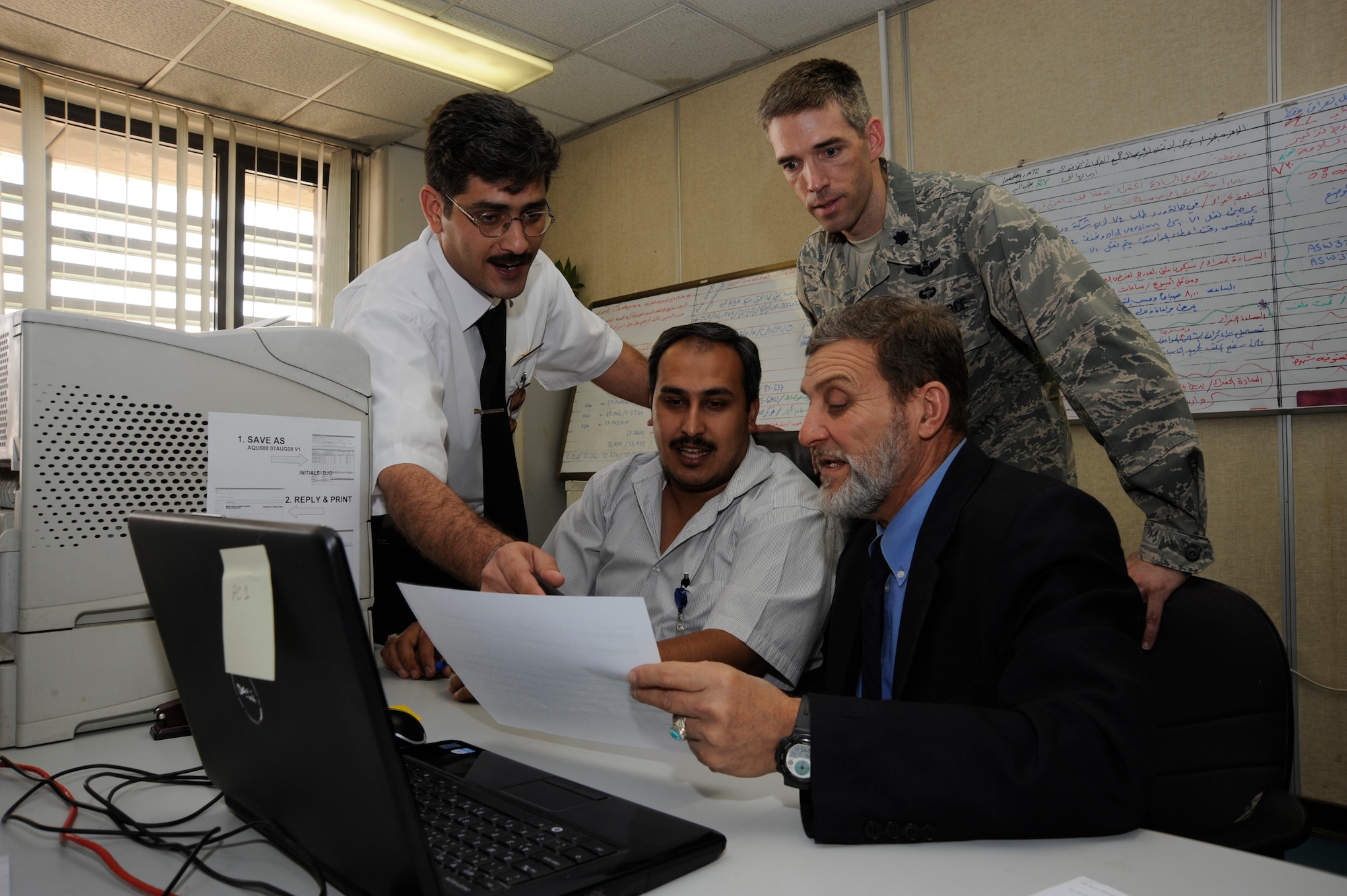 BAHGDAD -- Lt. Col. Dan Oosterhous, Regional Air Movement Control Center chief assigned to the Combined Air Operations Center in Southwest Asia, observes while members of the Iraqi Civil Aviation Authority here demonstrate their ability to properly approve and disapprove civil aircraft flights throughout Iraq Aug. 20, 2009. Colonel Oosterhous spent  60 days teaching the Iraqis to organize and archive their information on computer systems and use computer networks to process more than 400 daily flight requests and distribute a schedule to all aircraft command and control agencies throughout Iraq. Colonel Oosterhous is deployed from Scott Air Force Base, Ill., and is a native of Texarkana, Ark. (U.S. Air Force photo/Tech. Sgt. Johnny L. Saldivar/Released) 