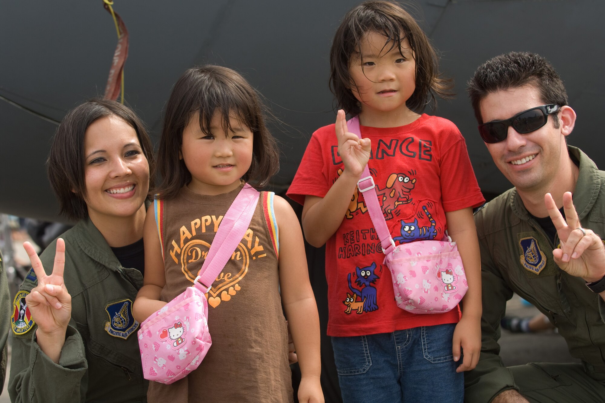 YOKOTA AIR BASE, Japan -- Capt. Jennifer Sherwood and Capt. Sean Silva, both from the 36th Airlift Squadron here, pose for a photo with Japanese children at a C-130 Hercules static display Aug. 22 during the first day of the two-day Yokota Air Base Japanese-American Friendship Festival. More than 80,000 people attended the first day. In addition to static displays and live music, the festival offered a variety of American and Japanese food items. The festival is designed to bolster the bi-lateral relationship shared by the United States and Japan.   (U.S. Air Force photo/Osakabe Yasuo)