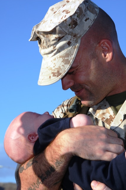 Sgt. Jeremy Quackenbush holds his 5-week-old son Caerus for the first time after returning from a deployment with the 31st Marine Expeditionary Unit in Okinawa, Japan, Aug.23 at Victory Field.