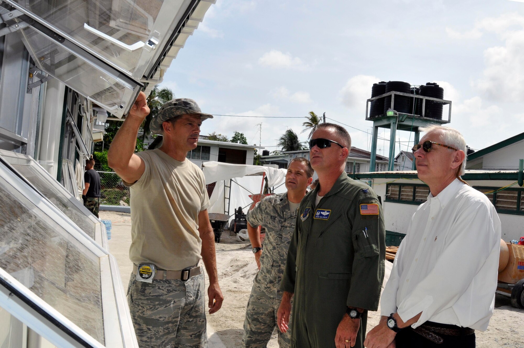 Chief Master Sgt. Steve Milhollin, chief engineer for the Bel Air School site, briefs Lt. Col. John Buse, Chief of Engineering for New Horizons Guyana, Col. Douglas Galipeau, 474th Air Expeditionary Group Commander, and Mr. Ken Popelas, 474th Air Expeditionary Group Deputy Commander, on the benefits of using the type of windows on the school, Aug 20, 2009, at the Bel Air School, Georgetown, Guyana. Col. Galipeau visited two Medical Readiness and Training Exercises, one Dental Readiness and Training Exercise, an orphanage, and two construction projects all part of New Horizons Guyana. (U.S. Air Force photo by Airman 1st Class Perry Aston) (Released)