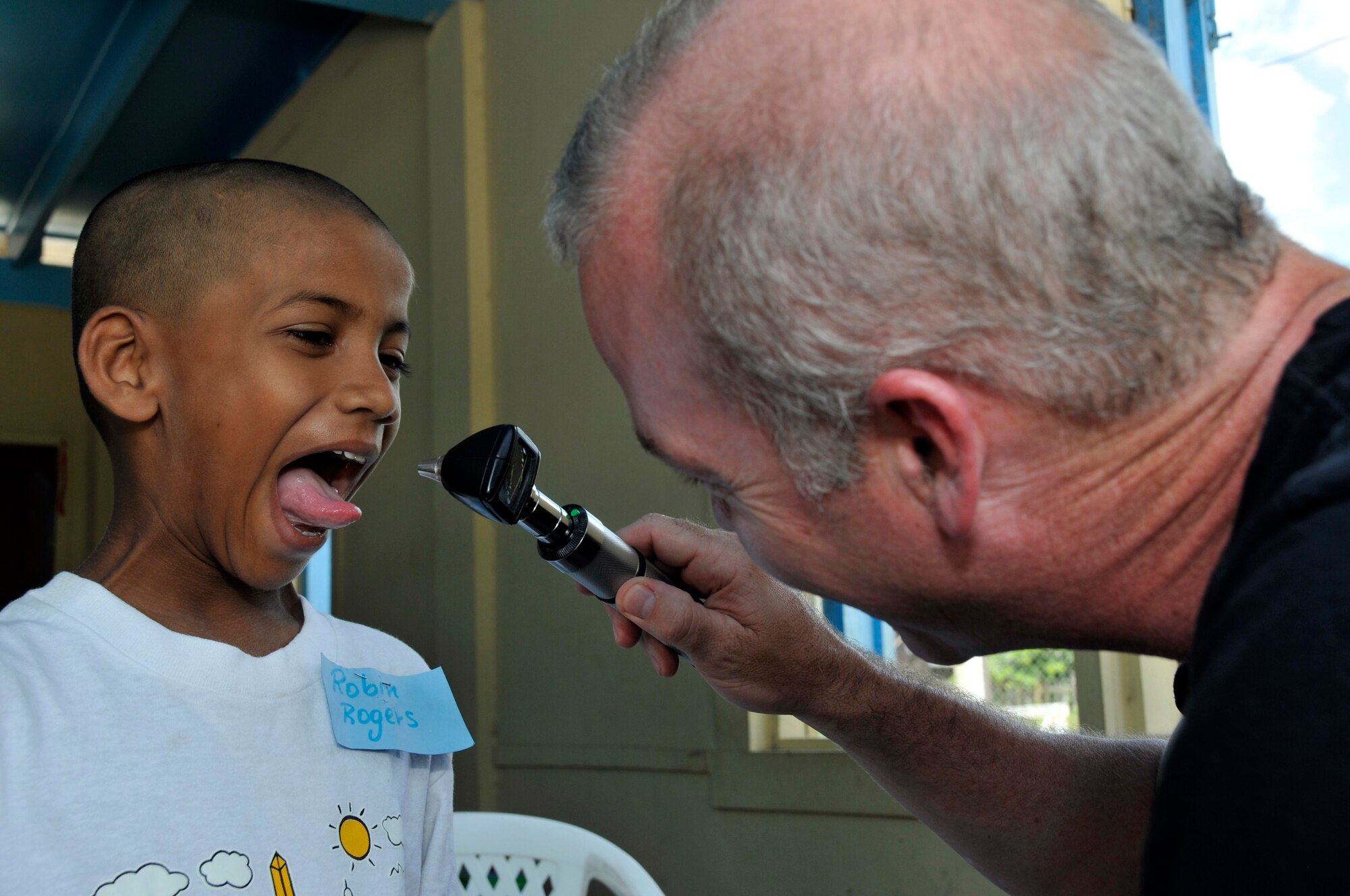 Robin Rogers from Joshua's Place Orphanage recieves a check up from Maj. (Dr.) James Sullivan, Physician from 710th Medical Squadron, Offutt AFB, Nebraska, Aug 18, 2009. Marines from the 4th Civil Affairs Group, Anacostia Naval Station, Washington DC, brought the children to the school for free medical check ups, dental and eye care. (U.S. Air Force photo by Airman 1st Class Perry Aston) (Released)