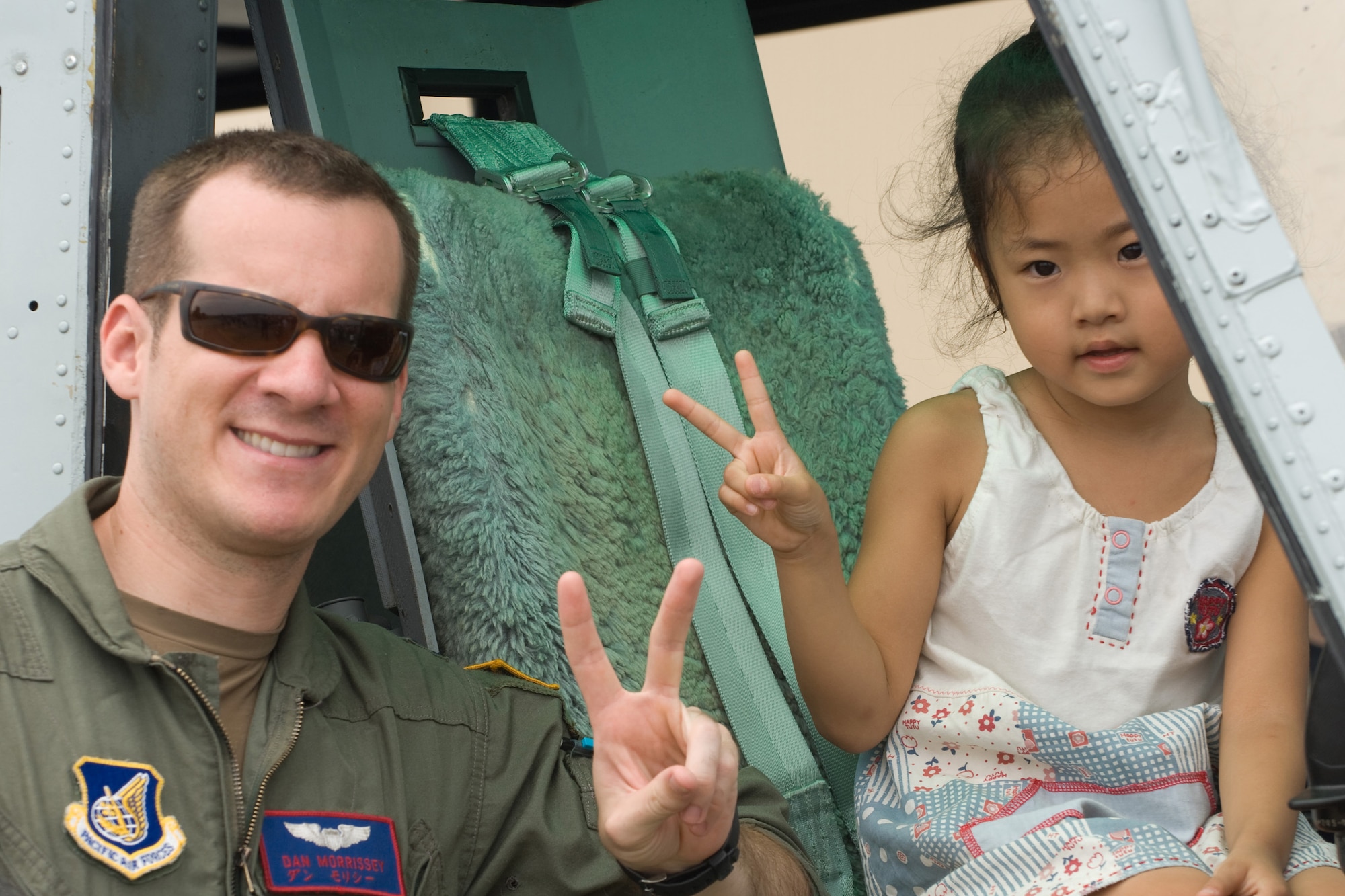 YOKOTA AIR BASE, Japan -- Capt. Daniel Morrissey, 459th Airlift Squadron, poses for a photo with a Japanese child at a UH-1 Huey static display Aug. 23 during the two-day Yokota Air Base Japanese-American Friendship Festival. More than 170,000 people attended the festival. In addition to static displays and live music, the festival offered a variety of American and Japanese food items. The festival is designed to bolster the bi-lateral relationship shared by the United States and Japan. (U.S. Air Force photo/Osakabe Yasuo) 