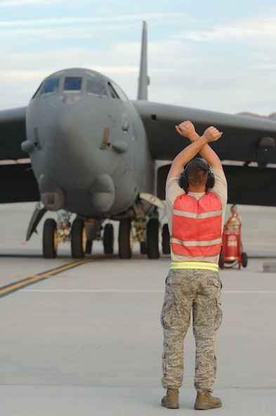 NELLIS AIR FORCE BASE, Nev. -- Staff Sgt.. Luke Hartsuff, 2d Maintenance Squadron, marshals a B-52, which landed here Aug. 21. The BUFF, assigned to the 20th Bomb Squadron, Barksdale AFB, La., is here to participate in Red Flag 09-5, an intense two-week combat scenario exercise. Red Flag is conducted on the 15,000-square-mile Nevada Test and Training Range, north of Las Vegas. The exercise is one of a series of advanced training programs administered by the U.S. Air Force Warfare Center and Nellis, through the 414th Combat Training Squadron. (U.S. Air Force photo by Staff Sgt. Sarah E. Stegman)(RELEASED)