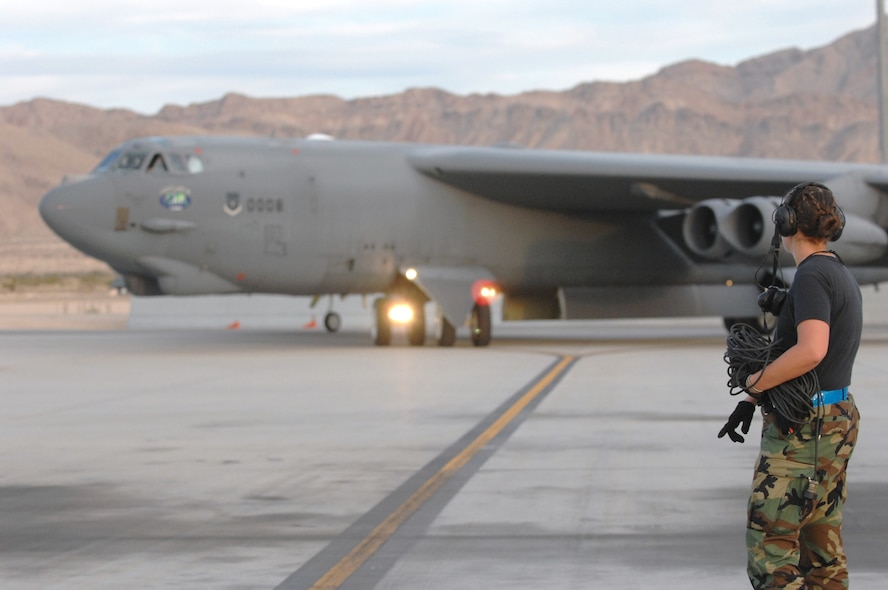 NELLIS AIR FORCE BASE, Nev. -- Senior Airman Kristin Horton directs a B-52 here Aug. 21. The BUFF, assigned to the 20th Bomb Squadron, Barksdale AFB, La., is here to participate in Red Flag 09-5, an intense two-week combat scenario exercise. . Red Flag is conducted on the 15,000-square-mile Nevada Test and Training Range, north of Las Vegas. The exercise is one of a series of advanced training programs administered by the U.S. Air Force Warfare Center and Nellis, through the 414th Combat Training Squadron. (U.S. Air Force photo by Staff Sgt. Sarah E. Stegman)(RELEASED)