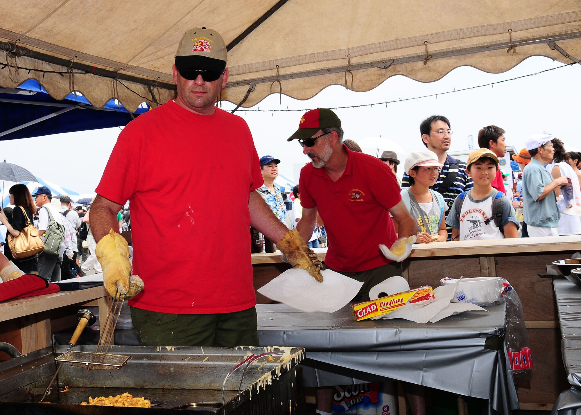YOKOTA AIR BASE, Japan -- Barry Eddins, Yokota Boy Scout Troop 45 leader, (left) makes funnel cakes Aug. 23 during the 2009 Yokota Air Base Japanese-American Friendship Festival. More than 170,000 people attended the two-day event. In addition to static displays and live music, the festival offered a variety of American and Japanese food items. The festival is designed to bolster the bi-lateral relationship shared by the United States and Japan. (U.S. Air Force photo/Airman Sean Martin)