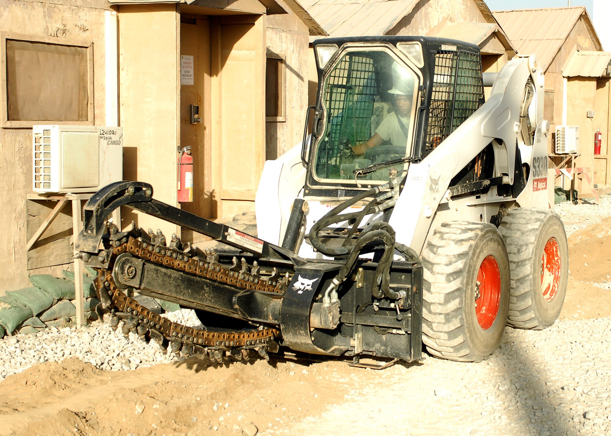 BAGRAM AIRFIELD, Afghanistan - Senior Airman Roberto Reyes, from the 455th Expeditionary Communications Squadron, uses heavy machinery to cut a channel in order to lay cables here, Aug. 21. The 455th ECS is tasked with laying all the necessary cables to assure all work places have internet and phone lines. Airman Reyes, a native of Killeen, Texas, is deployed from Barksdale Air Force Base, La. (U.S. Air Force photo/Senior Airman Felicia Juenke)