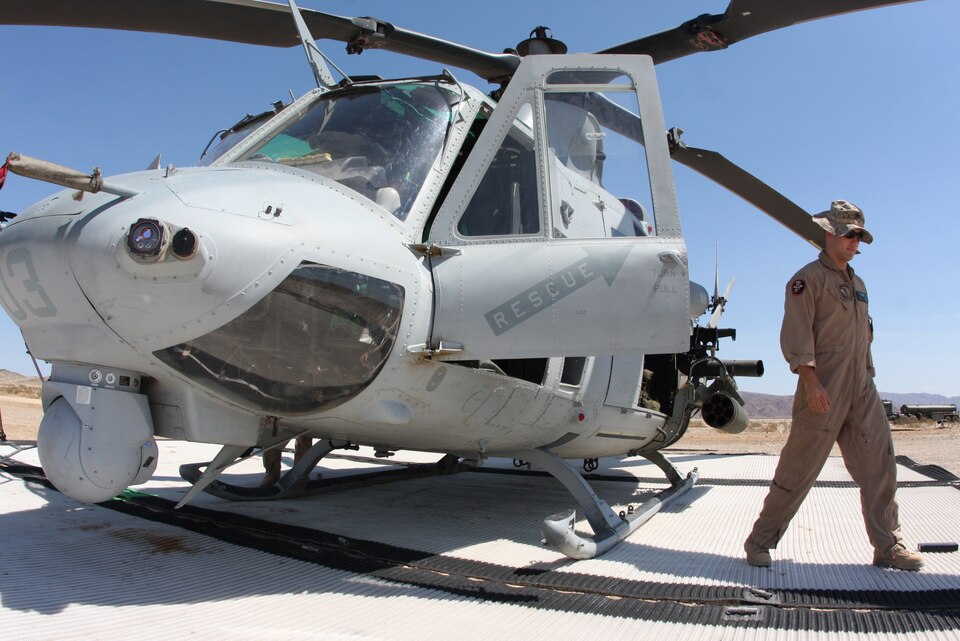 Capt. Kyle Wilt, a UH-1 Yankee Super Huey pilot with Marine Light Attack Helicopter Squadron 367, walks around the aircraft after checking its operational equipment during Enhanced Mojave Viper training with Marine Wing Support Squadron 372 at the Combat Center's Prospect training area Aug. 25.
