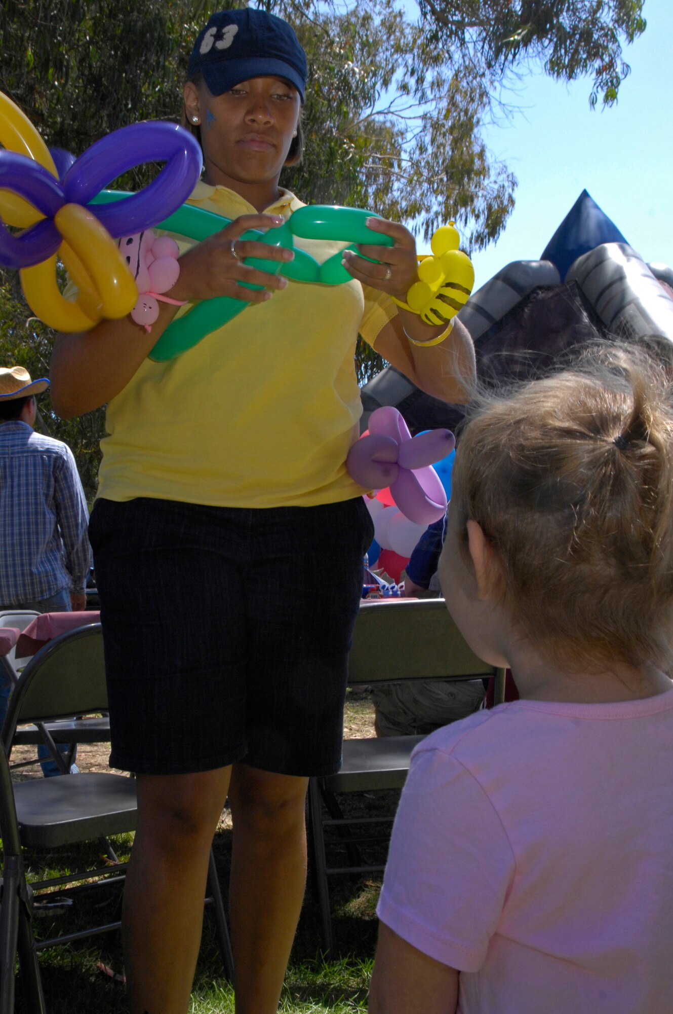 VANDENBERG AIR FORCE BASE, Calif. --  Ema Warren, who is the daughter of 2nd Lt. Aaron Warren of the 392nd Training Squadron, patiently waits while 2nd Lt. Monique Brown forms a balloon flower for her during the Texas Blowout here Aug. 21. Last year's Texas Blowout event helped raise $20,000 for the Operation Kids' Christmas event. (U.S. Air Force photo/Airman 1st Class Andrew Lee) 
 