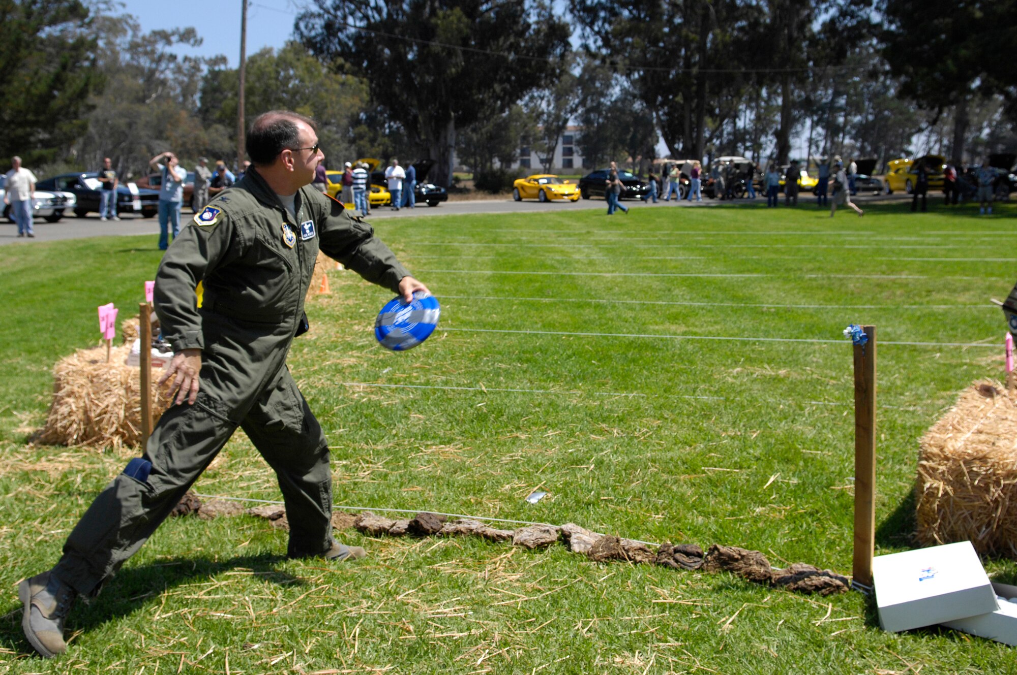 VANDENBERG AIR FORCE BASE, Calif. -- Kicking off the Texas Blowout cowchip tossing contest, 30th Space Wing vice commander Col. Steven Winters throws a cow pie like a frisbee at Cocheo Park here Aug. 21. The Texas Blowout also included a car show and silent auction.  (U.S. Air Force photo/Airman 1st Class Andrew Lee) 