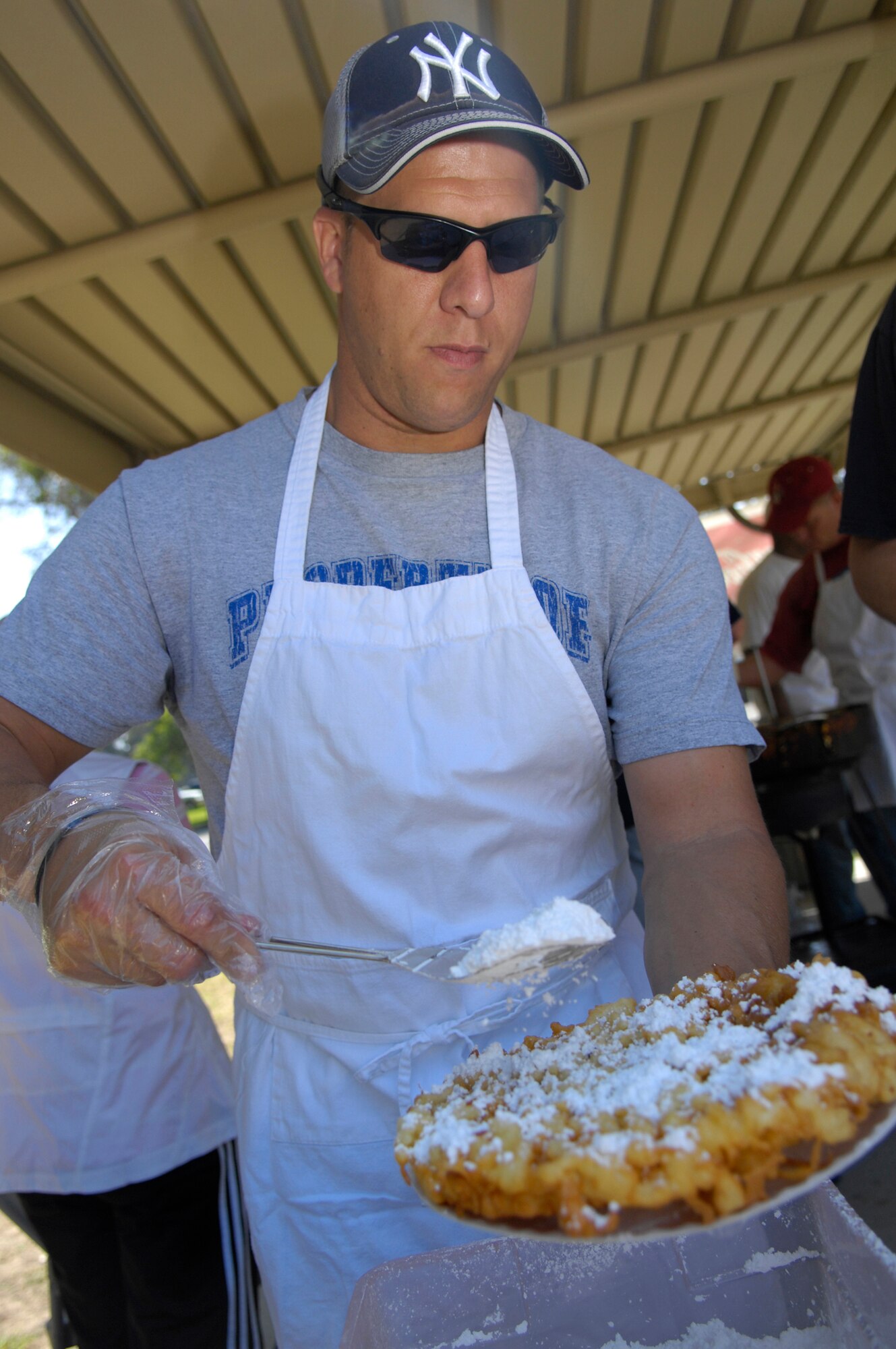 VANDENBERG AIR FORCE BASE, Calif. -- To add a sweet taste, Master Sgt. Jeffrey Lynn of the 30th Launch Support Squadron sprinkles powdered sugar on top of freshly made funnel cakes during the Texas Blowout at Cocheo Park here Aug. 21. The Texas Blowout included a barbecue and activites such as a cow chip toss, car show and silent auction. (U.S. Air Force photo/Airman 1st Class Andrew Lee) 
 