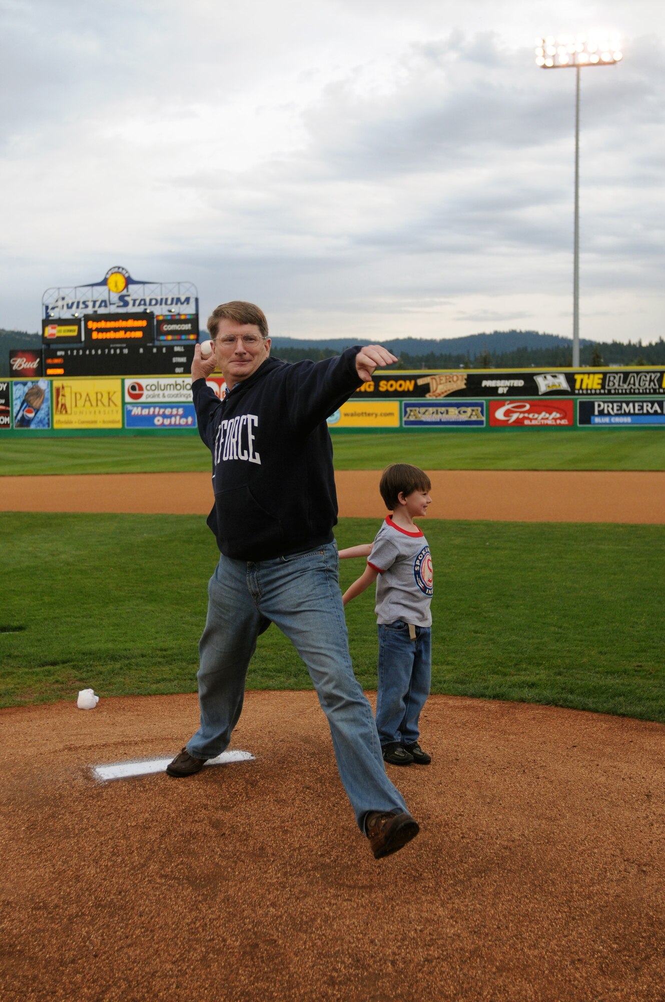 Col. Robert Thomas, 92nd Air Refueling Wing commander, throws the first pitch at the Spokane Indians Military Appreciation night Aug. 15 while his son Christian, 4, looks on. (Courtesy photo)