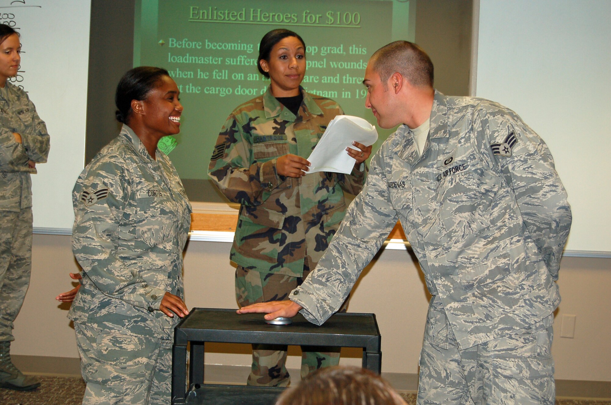 Senior Airman Melanie Curtis (left), 21st Aerospace Medicine Squadron and Senior Airman Andrew Cardenas, 3rd Weather Squadron Det. 1, stationed at Fort Carson, vie to answer a Jeopardy question Aug. 11, as Tech. Sgt. Alyse Partridge, former Air Force Enlisted Association president, moderates. The new learning tool made its debut the day before the class graduated and is part of the Airman Leadership School class here. Airman Curtis won the title of Levitow Award, the top award for academics and leadership at ALS. (Air Force photo by Thea Skinner)
