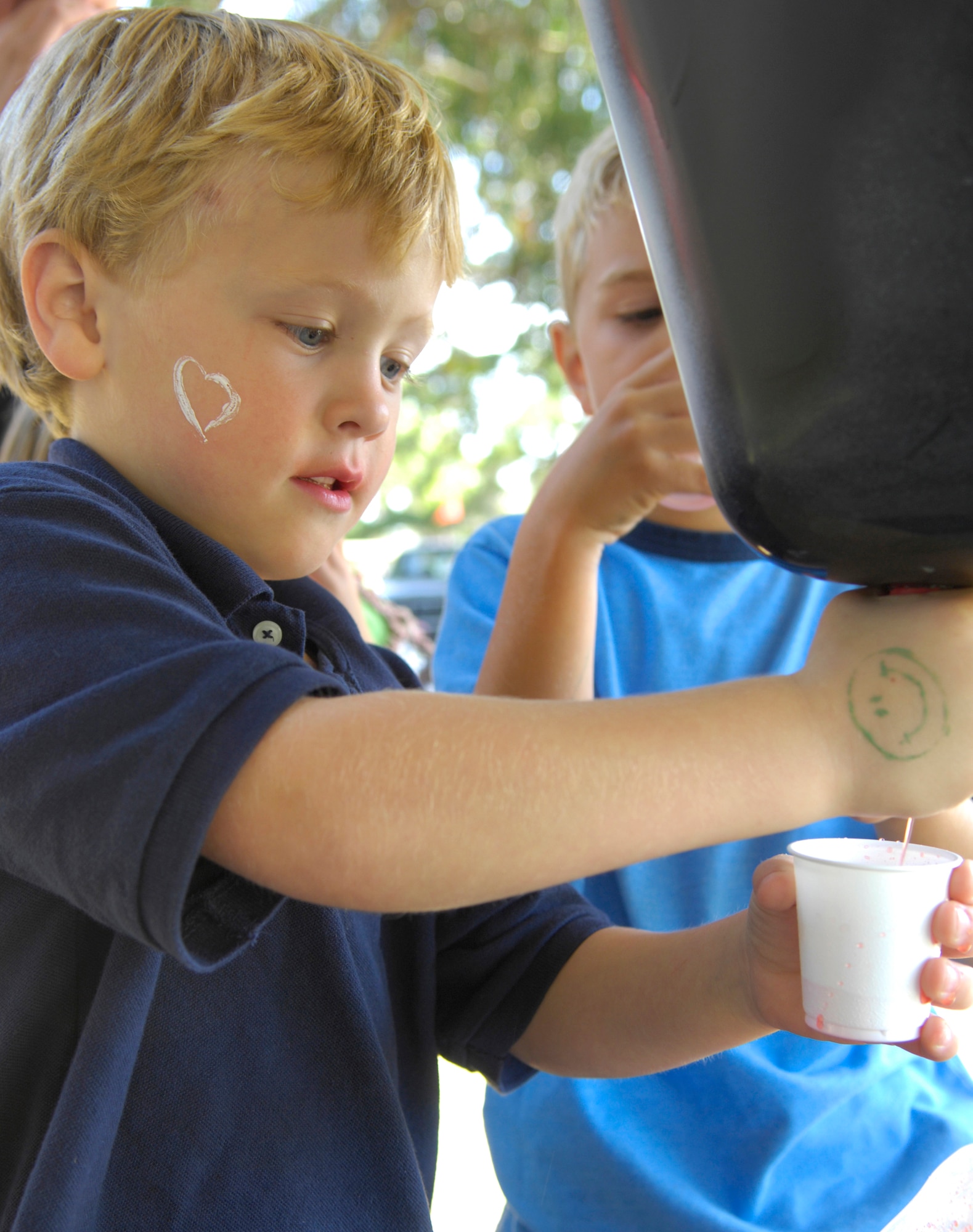 VANDENBERG AIR FORCE BASE, Calif. -- Jackson Hauboldt, who is the son of 4th Space Launch Sqaudron commander Lt. Col. Brady Hauboldt, uses a mock cow udder to squeeze juice into a cup during the Texas Blowout at Cocheo Park here Aug. 21. The Texas Blowout, which includes a barbecue and activities such as a car show, is the biggest fundraiser for Operation Kids' Christmas. (U.S. Air Force photo/Airman 1st Class Andrew Lee) 