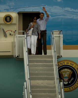 President Barack Obama emerges from Air Force One with a wave to the crowd and his daughter Malia at his side shortly after landing at the Massachusetts Military Reservation on Aug. 23, 2009. President Obama and The First Family landed at the MMR in Air Force One and within minutes boarded Marine One headed for a week-long vacation on Martha's Vineyard.