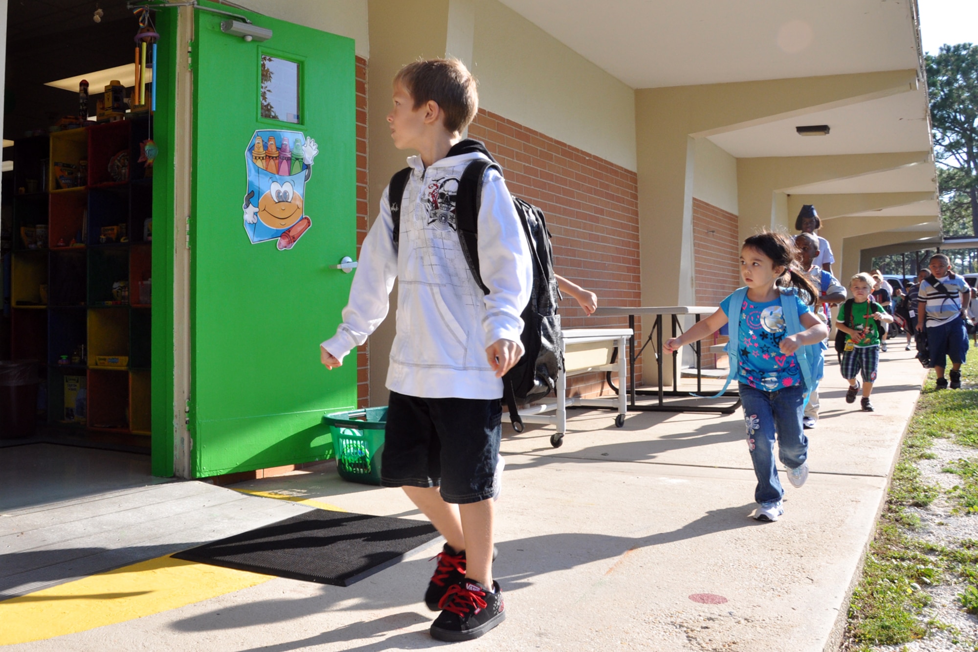 EGLIN AIR FORCE BASE, Fla. – Children rush to begin their first day back in school Aug. 24, at Eglin Elementary school. Drivers are reminded to keep a careful eye out as children will be to and from bus stops in the mornings and afternoons. Eglin drivers should slow down and stop for school buses and remain alert for children crossing. (U.S. Air Force photo/ Airman Anthony Jennings)