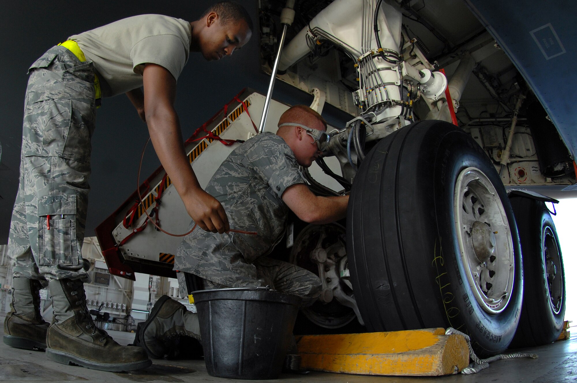 WHITEMAN AIR FORCE BASE, Mo. – Airman 1st Class Benjamin Feldkamp,(right) 509th Aircraft Maintenance Squadron crew chief, safety wires a break bleed port on a B-2 Spirit prior to takeoff, Aug. 22, 2009. Airman Feldkamp and other AMXS crew chiefs work around the clock to ensure the B-2 is mission ready at all times. (U.S. Air Force photo/Senior Airman Kenny Holston)