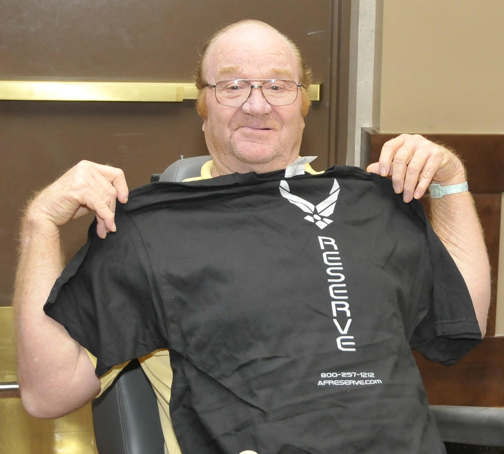 Former Air Force member Jimmy Davis, who served in the 1960's, poses with an Air Force Reserve shirt he won during bingo Aug. 20 at the Veteran's Center in Lawton, Okla. Sheppard's Top-3 teamed up with their colleagues from Altus Air Force Base, Okla. to show veterans their service has not been forgotten when they visited the long-term nursing center. (U.S. Air Force photo/Tech. Sgt. Matthew Beauregard)
