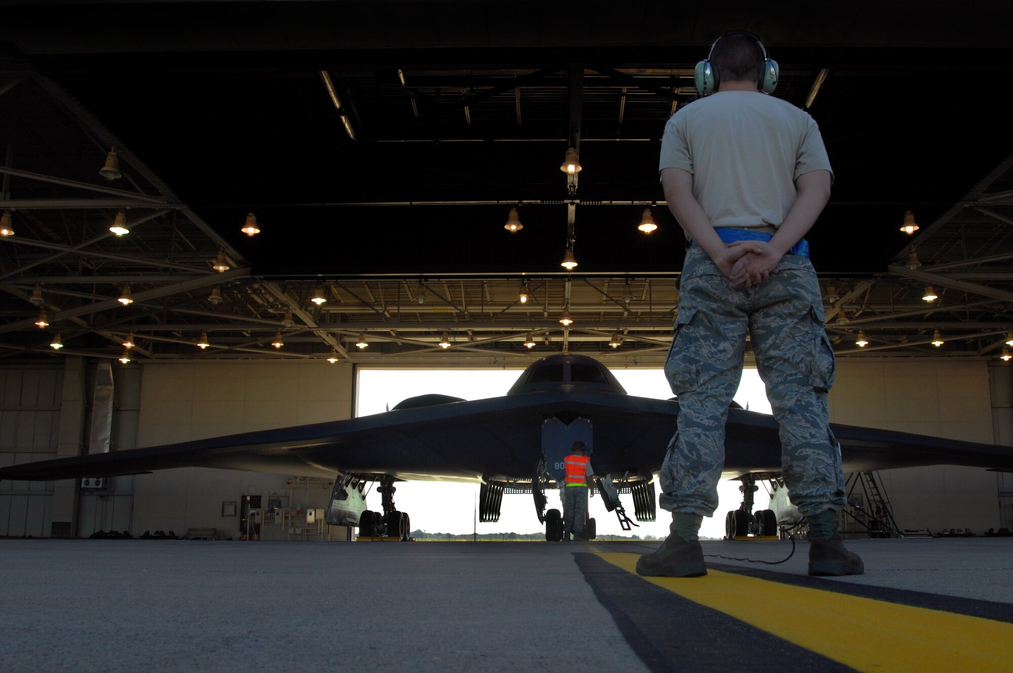 WHITEMAN AIR FORCE BASE, Mo. – Senior Airman Douglas Anthony, 509th Aircraft Maintenance Squadron crew chief, stands prepared to marshal a B-2 Spirit out of a hanger for takeoff, Aug. 22, 2009.  Twenty B-2 Spirit aircrafts are assigned to the 509th Bomb Wing. The B-2 brings massive firepower to bear, in a short time, anywhere on the globe through previously impenetrable defenses. (U.S. Air Force photo/Senior Airman Kenny Holston)