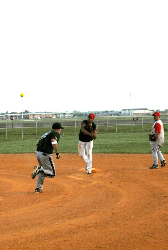 LANGLEY AIR FORCE BASE, Va. -- 1st Equipment Maintenance Squadron Bulldogs' first baseman throws a ball to home plate after getting the runner out during the Langley Intramural Softball League Championship here Aug. 18. (U.S. Air Force courtesy photo)
