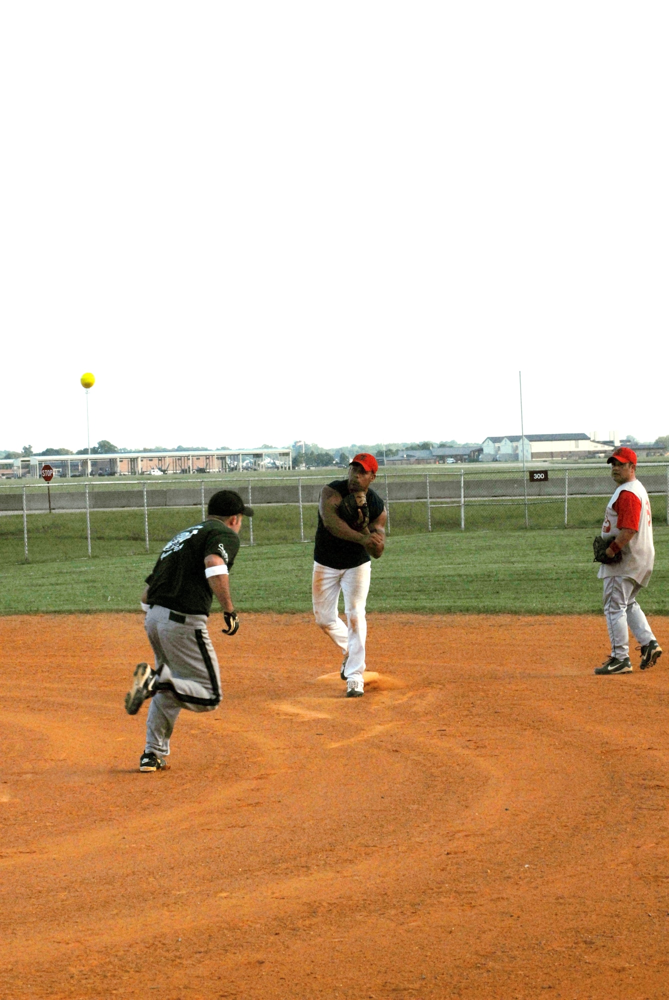 LANGLEY AIR FORCE BASE, Va. -- 1st Equipment Maintenance Squadron Bulldogs' first baseman throws a ball to home plate after getting the runner out during the Langley Intramural Softball League Championship here Aug. 18. (U.S. Air Force courtesy photo)