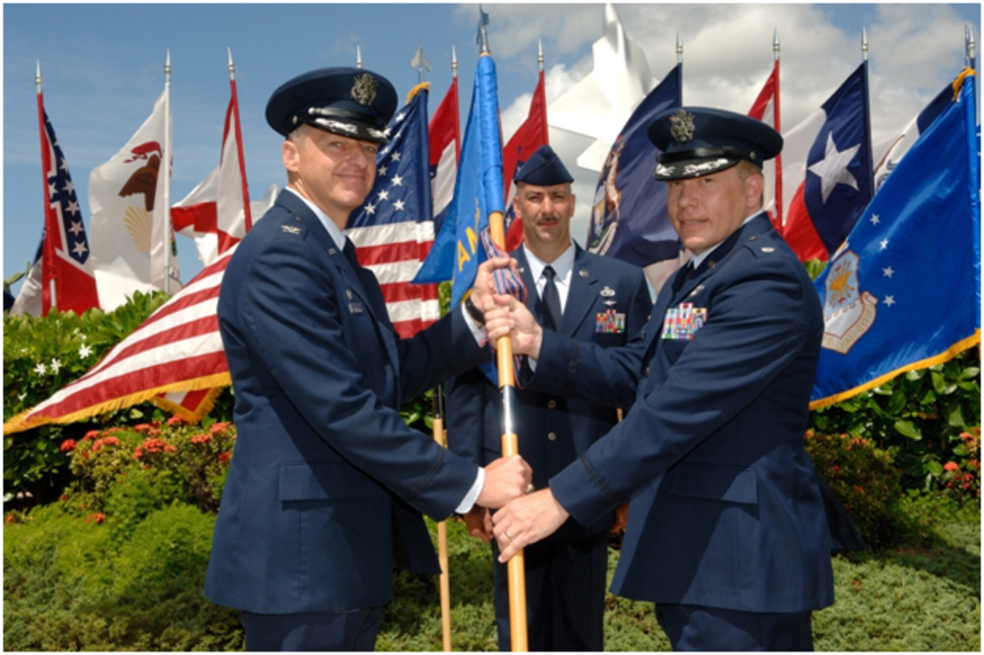HICKAM AIR FORCE BASE, Hawaii -- Col. Jeffrey G. Mintzlaff, 715th Air Mobility Operation Group commander, passes the Squadron guidon to Lt. Col. Jeffrey G. Pierce as he accepts command of the 735th Air Mobility Squadron July 27. (U.S. Air Force photo/Mark Bates)